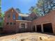 Spacious, two-story brick home with ample windows and a three-car garage in a wooded setting at 1500 Ridge Rd, Raleigh, NC 27607