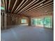 Partially constructed living room with sliding door, large windows, and exposed ceiling beams at 1500 Ridge Rd, Raleigh, NC 27607