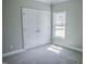 Bright bedroom features plush carpet, double door closet, and natural light from a window at 155 Diamond Creek Dr, Zebulon, NC 27597