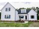 Charming two-story home featuring white siding, black trim, inviting front porch and a well-manicured lawn at 155 Diamond Creek Dr, Zebulon, NC 27597