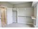 Spacious walk-in closet with custom shelving and a view of the ensuite bathroom with tiled shower at 155 Diamond Creek Dr, Zebulon, NC 27597