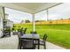 Outdoor patio space with chairs, a dining table, and a view of the grassy backyard with a privacy fence at 1606 Garden Park Cir, Fuquay Varina, NC 27526