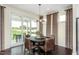 Dining room features modern chandelier, brown dining chairs, and access to the backyard through sliding glass doors at 1606 Garden Park Cir, Fuquay Varina, NC 27526