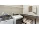 Modern laundry room with front-loading washer and dryer, wire shelving, and a folding table at 1606 Garden Park Cir, Fuquay Varina, NC 27526
