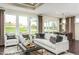 Sunlit living room featuring large windows, stylish furniture, and hardwood floors at 1606 Garden Park Cir, Fuquay Varina, NC 27526