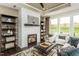 Cozy living room with fireplace, built-in shelving, and plenty of natural light at 1606 Garden Park Cir, Fuquay Varina, NC 27526