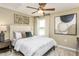 Comfortable bedroom featuring a ceiling fan, neutral walls, a large window, and a well-dressed queen-sized bed at 1606 Garden Park Cir, Fuquay Varina, NC 27526