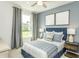 Cozy bedroom with blue walls, a ceiling fan, and a large window with natural light at 1614 Garden Park Cir, Fuquay Varina, NC 27526