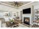 Cozy living room with a fireplace, ceiling fan, and open to the kitchen and dining areas at 1614 Garden Park Cir, Fuquay Varina, NC 27526