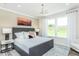 Bright bedroom featuring a gray bed frame, stylish chandelier, and natural light from the window at 1622 Garden Park Cir, Fuquay Varina, NC 27526