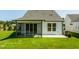 Back exterior showcasing a screened-in porch and lush lawn, ideal for outdoor entertaining at 1622 Garden Park Cir, Fuquay Varina, NC 27526