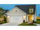 Charming home exterior with a well-lit two-car garage and landscaped front yard at 1622 Garden Park Cir, Fuquay Varina, NC 27526