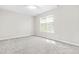 Bright bedroom with neutral walls, plush carpeting, and a large window at 1628 Briarmont Court Ct, Raleigh, NC 27610