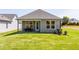 Well-maintained backyard featuring lush lawn and a covered patio with outdoor seating, perfect for entertaining guests at 1630 Garden Park Cir, Fuquay Varina, NC 27526