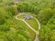Stunning aerial view of home surrounded by lush greenery and a winding driveway at 169 Country Brooke Lane Ln, Roxboro, NC 27574