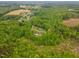 Expansive aerial view of a wooded lot with a home nestled among mature trees and a winding stream at 169 Country Brooke Lane Ln, Roxboro, NC 27574
