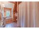 Rustic bathroom featuring a wood-paneled ceiling, a corner window, and a combination tub/shower at 169 Country Brooke Lane Ln, Roxboro, NC 27574