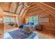 Charming bedroom featuring wood-paneled walls and ceiling with two windows and a colorful rug at 169 Country Brooke Lane Ln, Roxboro, NC 27574