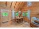 Charming dining area with wood table and chairs, bright windows, and natural wood walls and ceiling at 169 Country Brooke Lane Ln, Roxboro, NC 27574