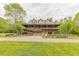 Beautiful two-story stone home with a metal roof, surrounded by lush greenery and a well-manicured lawn at 169 Country Brooke Lane Ln, Roxboro, NC 27574