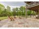 Cozy outdoor stone patio with fireplace and wooden seating area at 169 Country Brooke Lane Ln, Roxboro, NC 27574