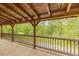 Spacious covered porch with wooden railing, offering serene views of the surrounding landscape and natural beauty at 169 Country Brooke Lane Ln, Roxboro, NC 27574