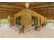 Inviting covered porch with wood beams, stone accents, and a cozy bench, perfect for enjoying the outdoors at 169 Country Brooke Lane Ln, Roxboro, NC 27574