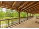 Expansive wooden porch with railing offering scenic views of lush greenery and a peaceful outdoor setting at 169 Country Brooke Lane Ln, Roxboro, NC 27574