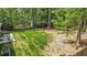 Large backyard with patio furniture and grill, surrounded by mature trees and fencing at 1800 Tarbert Dr, Cary, NC 27511