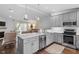 Open-concept kitchen with gray cabinets, stainless steel appliances, and center island at 1800 Tarbert Dr, Cary, NC 27511