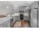 Well-lit kitchen with gray cabinets, stainless appliances, and tiled backsplash at 1800 Tarbert Dr, Cary, NC 27511