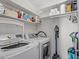 Functional laundry room equipped with washer, dryer, shelves, and cleaning supplies at 1800 Tarbert Dr, Cary, NC 27511