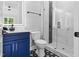 This bathroom features a modern vanity with blue cabinets, decorative floor tiles, and a glass-enclosed shower at 1903 Edgerton Dr, Durham, NC 27703