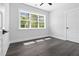 Bright bedroom with a large window providing natural light and wood look floors at 1903 Edgerton Dr, Durham, NC 27703
