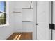 Bright walk-in closet features built-in shelving, rod, hardwood floors, and a window for natural light at 1903 Edgerton Dr, Durham, NC 27703
