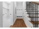 Foyer with hardwood floors, bench with coat hooks, and staircase with wrought iron spindles at 1903 Edgerton Dr, Durham, NC 27703