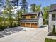 Spacious three-car garage with wooden doors and a living space above it at 1903 Edgerton Dr, Durham, NC 27703