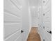 Long hallway with hardwood floors, white walls, and multiple doors at 1903 Edgerton Dr, Durham, NC 27703