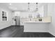 Modern kitchen featuring white cabinets, stainless steel appliances, and a stylish breakfast bar with pendant lighting at 1903 Edgerton Dr, Durham, NC 27703