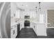 Well-lit kitchen showcasing stainless steel appliances, white cabinetry, quartz countertops and modern pendant lights at 1903 Edgerton Dr, Durham, NC 27703