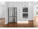 Stainless appliances including refrigerator and double oven built into bright white custom cabinetry at 1903 Edgerton Dr, Durham, NC 27703