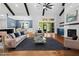 Well-lit living room with wood floors, a ceiling fan, a fireplace, and a view of the dining area at 1903 Edgerton Dr, Durham, NC 27703