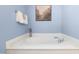 Bathroom showcasing a soaking tub with chrome fixtures and blue walls at 210 Millet Dr, Morrisville, NC 27560