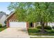 Attractive single-Gathering home featuring a brick facade, attached garage, mature shade tree, and concrete driveway at 210 Millet Dr, Morrisville, NC 27560