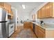 Well-lit kitchen featuring wood cabinets, stainless steel appliances, and hardwood flooring at 210 Millet Dr, Morrisville, NC 27560
