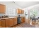 Bright kitchen with wood cabinets, stainless steel appliances, tile backsplash, and breakfast nook with natural light at 210 Millet Dr, Morrisville, NC 27560