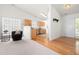 Bright living room and kitchen featuring hardwood floors, natural light, a cozy chair, and stainless steel appliances at 210 Millet Dr, Morrisville, NC 27560