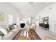 Airy living room featuring modern furnishings, fireplace, and open access to the kitchen and dining area at 210 Millet Dr, Morrisville, NC 27560