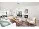 Well-lit living room featuring a fireplace, stylish furnishings, and an open layout leading to the kitchen and dining area at 210 Millet Dr, Morrisville, NC 27560