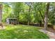 Lush backyard featuring a storage shed with stairs leading to a small deck at 2114 Woodview Dr, Raleigh, NC 27604